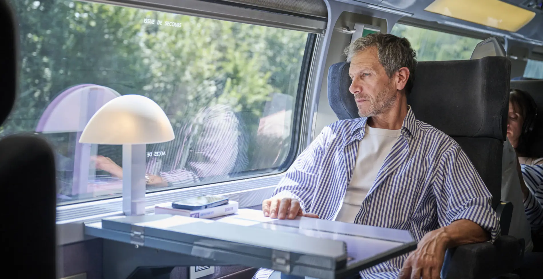 Une voyageuse en Standard admirant le paysage par la fenêtre