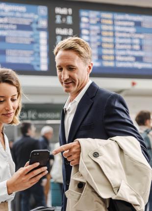 tgv lyria travellers in train station with smartphone