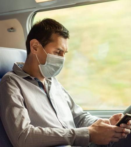 Man on board on his phone in 2nd class