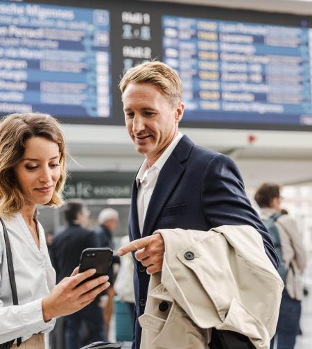 tgv lyria travellers in train station with smartphone