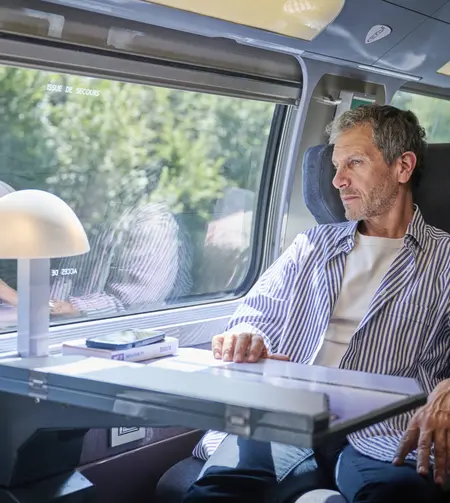 Une voyageuse en Standard admirant le paysage par la fenêtre